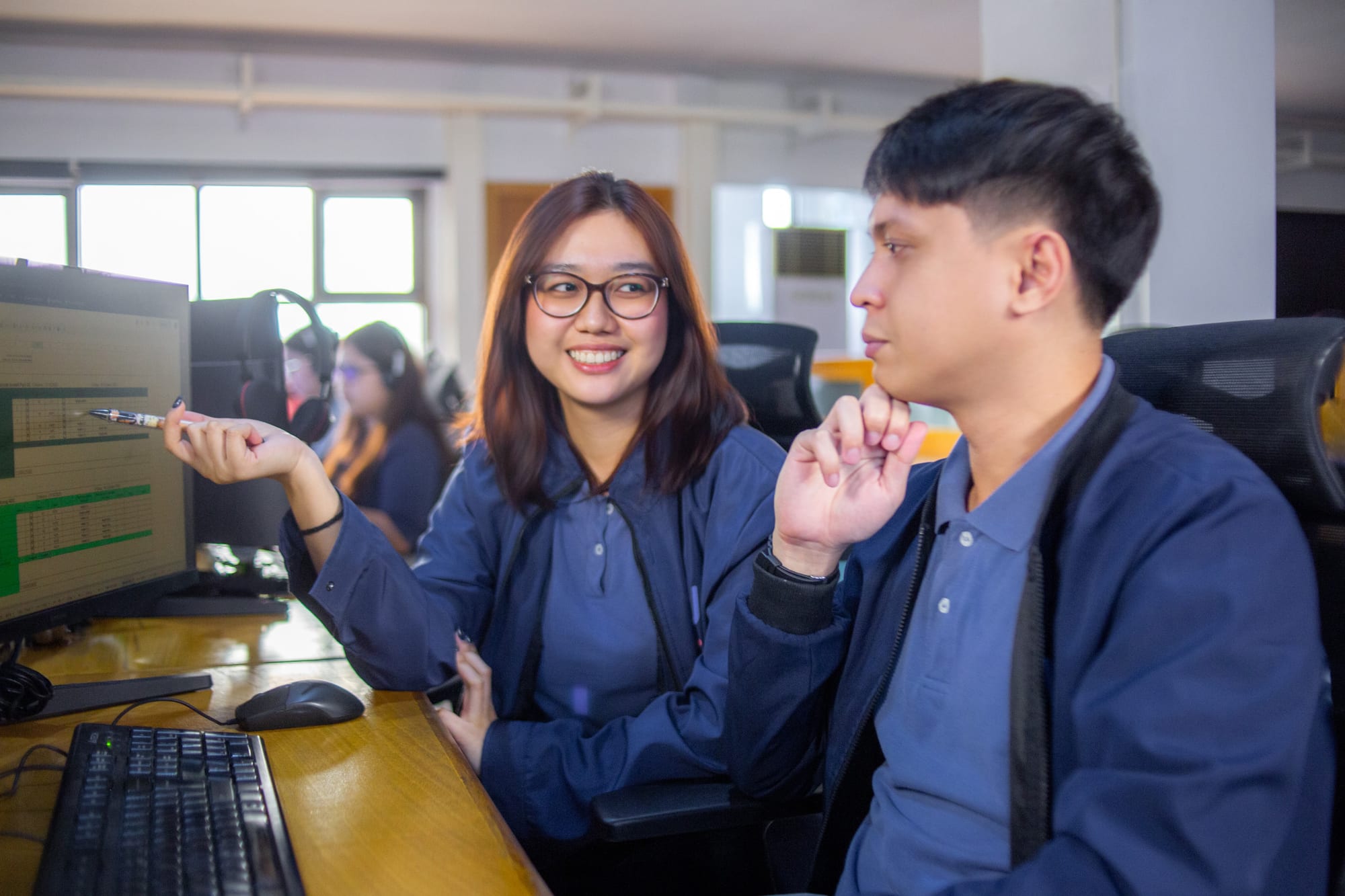 Two Yoonet team members reviewing work at a screen